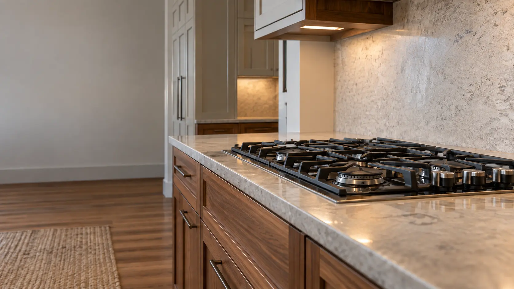 A Craftsman house kitchen with a gas cooktop in walnut cabinets, seen low along the counter, the cooktop surface catching the light.